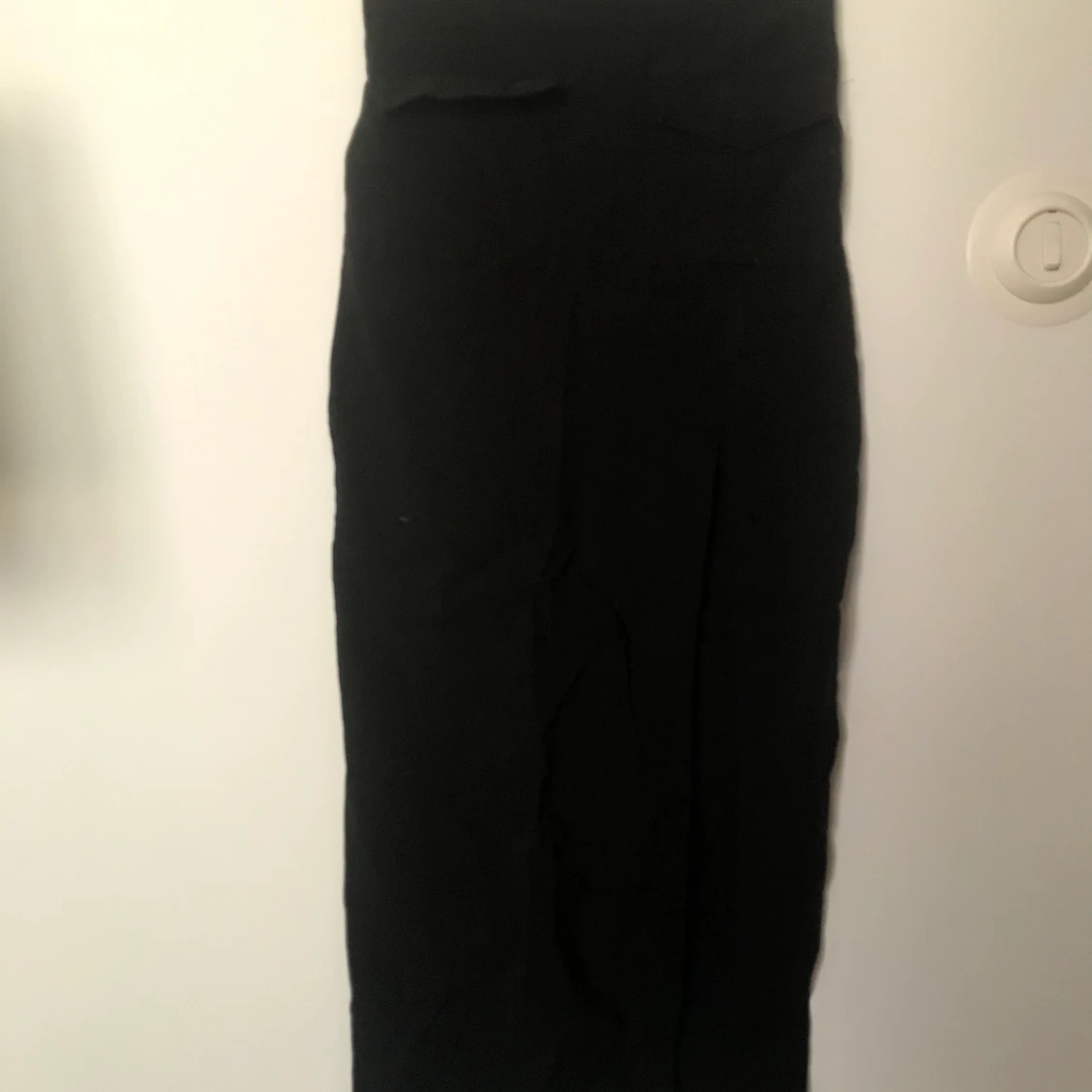 En lång, tajt, högmidjad svart kjol