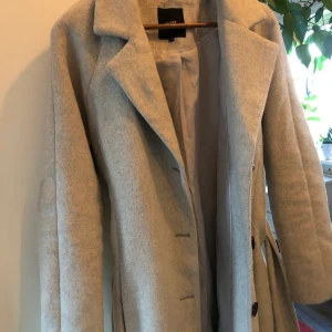 Grå kappa från Object  - Säljer min väldigt snygga kappa från object. Köpte den för 1600kr och säljer den för 400kr med fri frakt vid snabbt köp. Den har svarta knappar, knytsnöre och fickor som e praktiskt. Jag är runt 165 cm och den är till längre ner på vaderna på mig💕💕