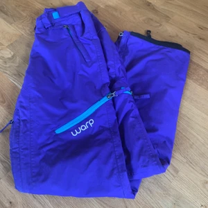 W*RP täckbyxor - Skidbyxor från warp i en mörklila nyans med turkosa detaljer vid dragkedjorna. I fint skick💫 skickas via Postnord, köpare betalar frakten🍀