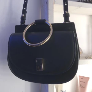 Väska med axelband  - En väska med axelband, ganska liten. Använd få gånger, ganska ny. Kan gå ner i pris om det önskas.