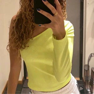 Neongul topp - Supercool neongul tröja i fint skick som bara har en ärm. Färgen ser man bättre på andra sliden. Köpt på Bershka i England! Passar jättebra nu till Halloween eller andra fester om man vill ha något neon på sig! :) 