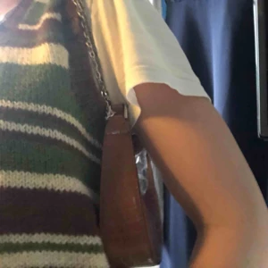 Handväska brun - Säljer handväska från asos som nu är helt slutsåld. Aldrig använd pga ej min stil därav är plasten fortfarande kvar. Nypris är 205kr. Kedja ingår. Kan mötas upp annars blir frakt 42kr