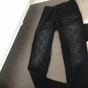  - Svarta mjuka byxor med svarta små pärlor.