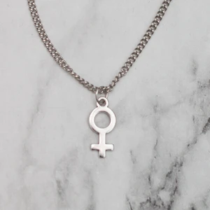 Halsband kvinnosymbol silver - Silverfärgat halsband med kvinnosymbolen, kedjan är ca 45cm. Fri frakt vid köp över 100:-