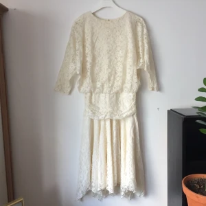  - Benvit spetsklänning, unik modell: vidd i överdelen, pingvinärm, åtsmitande, rynkat/draperat liv ii midjan och därefter vidd i kjolen (vintage? 60-tal?) mycket fint skick. Det står ”made in England”,  stl 10 i den. 