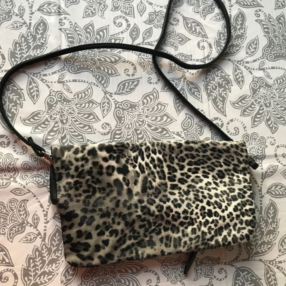 Väska med tunnt band, svart och grå leopardmönstrad. . Väskor.
