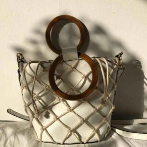  - Somrig väska köpt på Sportsgirl i Australien. Väska och ”påse” inuti med handtag i trä, i fint skick. Medkommer med axelband. Perfekt nu till våren och sommaren🌞