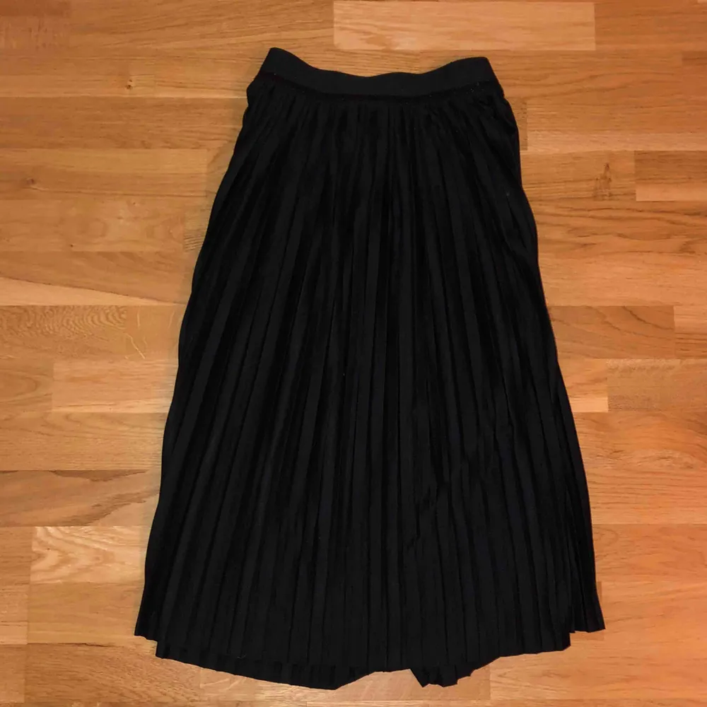 Lång plisserad, svart kjol med glitterkant upptill från Monki, i storlek M men passar S, fint skick. Köparen står för frakten.. Kjolar.