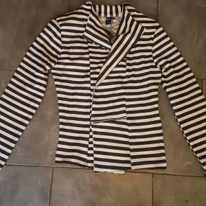 Kavaj ( soda) strl M - Kavaj från soda strl M, nyskick med prislapp kvar. Vit med marinblå ränder. Nypris 299 