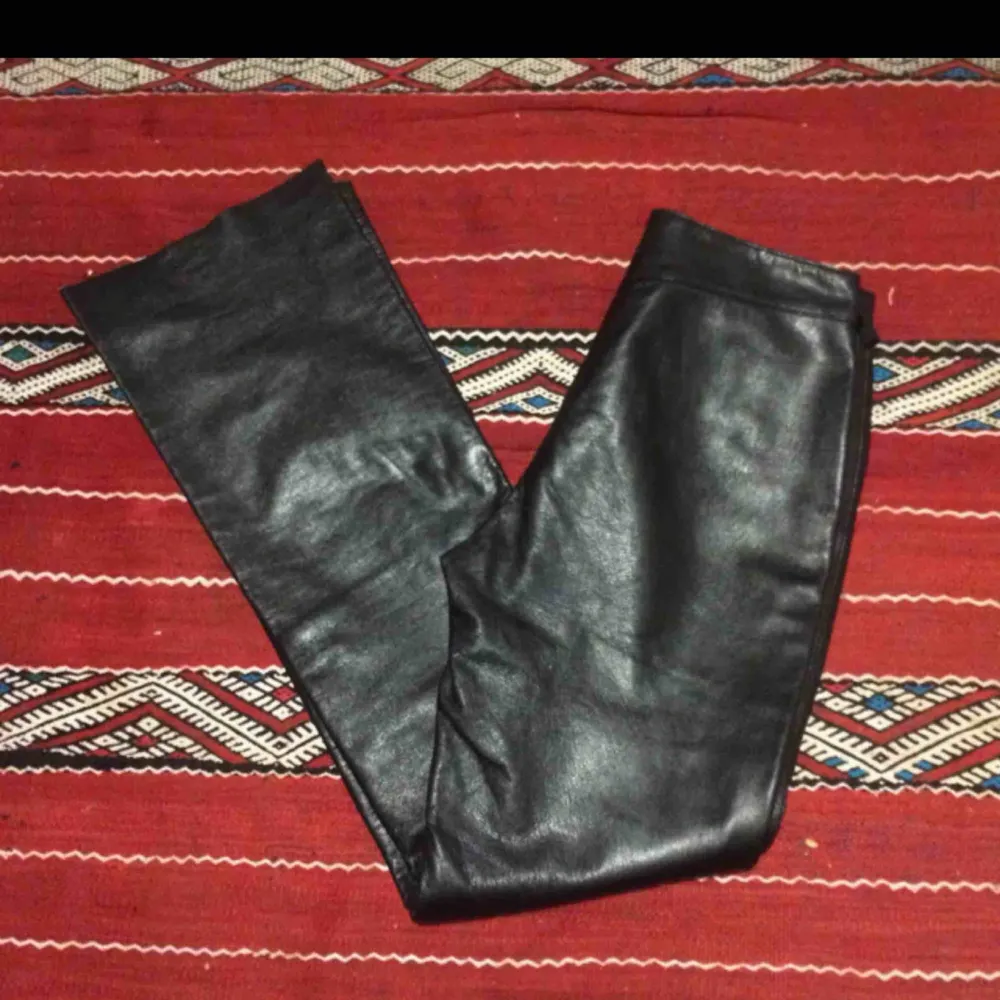 Svarta lätt utsvängda byxor i äkta skinn. Midjemått 80 cm, innebenslängd 85 cm ( men kan lätt kortas). Frakt 63 kr. (Säljer vidare dessa). Jeans & Byxor.