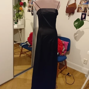  - Svart balklänning i glansigt tyg,  Super fin och bra skick.  Storklek xs, märke Vila. Betalning via swish, köparen står för frakten