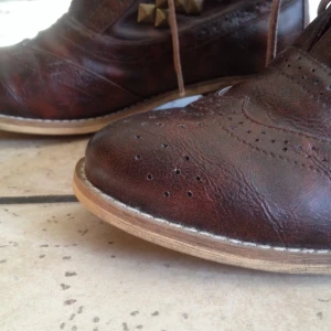 Nästan aldrig använda bruna boots med bronsfärgade nitar från Tiamo. - Nästan aldrig använda bruna boots med bronsfärgade nitar från Tiamo.