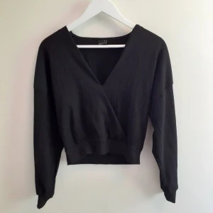 Croppad topp - En svart croppad omlott topp i finare material. Knappt använd så den ser ut som ny! Frakten ingår i priset💋