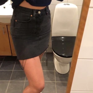 Jeanskjol - En svart/ grå jeans kjol från H&M med lite slitningar längst ner. Storlek 36 och passar mig som vanligtvis  har S/M. 