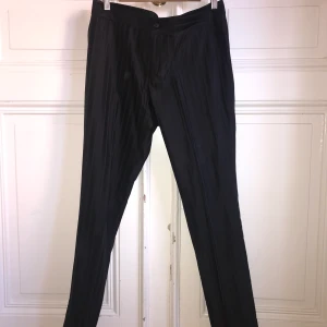 Tiger of Sweden  - Tiger of Sweden byxor. Byxorna är glansiga och har ett randigt mönster. 