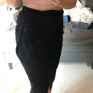 Svart kjol - Svart lite längre kjol med nån sorts snurr på sidan, stretchig. Aldrig använd 