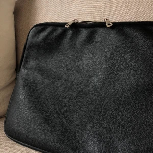 Datorfodral fr. Don Donna i läder - Datorfodral i utmärkt skick! Svart läder, silver dragkedja & beiget innertyg. Bra material då det tål kontakt m. vätska & annan smuts - lätt att torka bort! Passar 15’ laptop, även 13’ och då får man plats m kollegieblock/papper etc. Jag står för frakten!