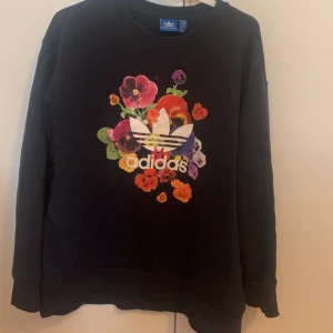 Mörblå adidaströja - Mörblå adidaströja men blommigt tryck. Strl 14, 50kr, köparen står för frakten