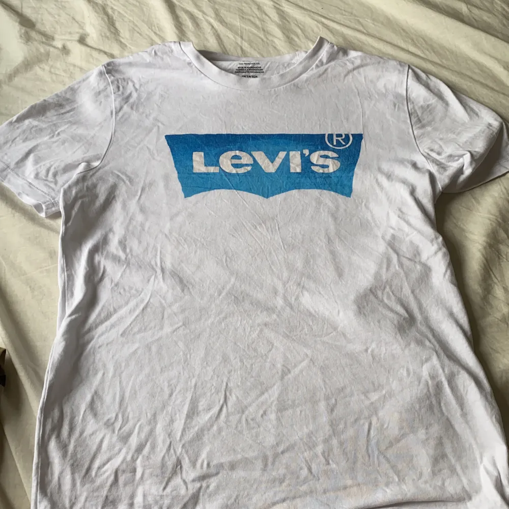 En vit levi’s t-shirt med ett blått tryck. ÄKTA. T-shirts.