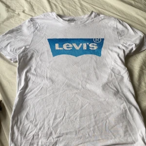 Vit t-shirt - En vit levi’s t-shirt med ett blått tryck. ÄKTA