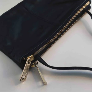  - Jättefin svart läderväska fån ”WERA Stockholm”, väskan har ”två delar”med mindre fack, justerbart axelband med guldiga detaljer. Ca 14x23cm.