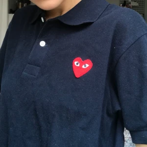  - Äkta Polo T-shirt från CDG play köp på Paul & friends. Nypris ca 1200. Använd fåtal gånger. Möts upp i Stockholm annars tillkommer frakt!