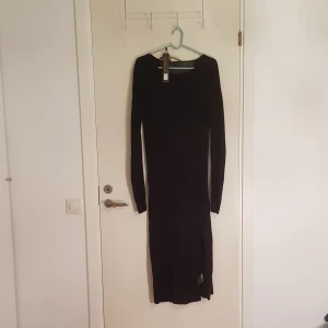  - Supertrash svart klänning med mesh insert i rygg och armar med hög slits. Googla supertrash darling så kan ni se hur den ser ut på. Den är tight. Superläcker för utekvällar. Oanvänd med lappen kvar. 