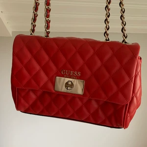 Röd Guess väska - Snygg väska från Guess. En slitning på baksidan av väskan som dock är ganska diskret, i övrigt jättefint skick. Köparen står för frakt!❤️