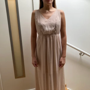 Långklänning med öppen rygg  - Vacker långklänning med fint fall. På andra bilden visas hur lång klänningen blir på någon som är 167 cm. Strl XS med justerbara band🌸 