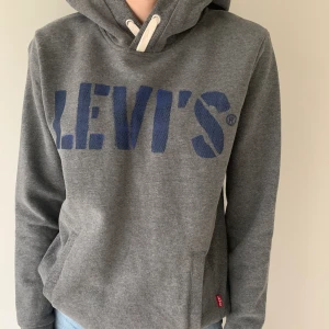 Mörkgrå LEVIS hoodie  - Säljer denna mörkgråa LEVIS hoodie i storlek 14 år, passar XS/S. Fint skick, lite nopprig på muddarna men inget som syns. Använd fåtal gånger. Spårbar frakt tillkommer på 63 kr