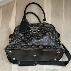 GUESS weekendbag duffle bag gymbag - Stor GUESS weekend väska i falskt läder. Sparsamt använd men få märken finns på kanter och liten tygskillnad (skrynklat till sig lite) på toppen som inte är synlig för ögat