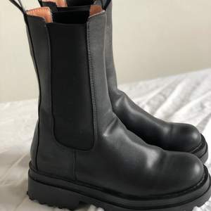 Matte leather mid-calf boots with super chunky, ribbed rubber soles and rubber toe caps. Storlek 38, men mer som än 37,5.