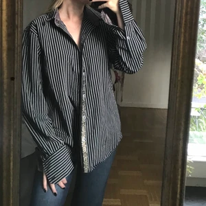 Randig skjorta - Unik och snygg skjorta från Scott Welland. Skjortan är i herrstorlek M, och sitter oversized på mig som har XS/S. Snygga detaljer på halskragen samt vid knapparna och ärmarna 🖤