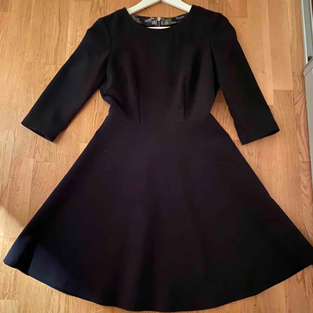 En klassisk svart klänning från Sand Copenhagen med vidd i kjolen och tydlig dragkedja som modern detalj på baksidan. Använd vid fåtal tillfällen så i nytt skick.. Klänningar.