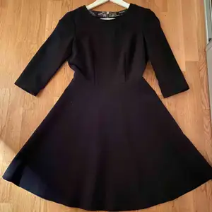 En klassisk svart klänning från Sand Copenhagen med vidd i kjolen och tydlig dragkedja som modern detalj på baksidan. Använd vid fåtal tillfällen så i nytt skick.