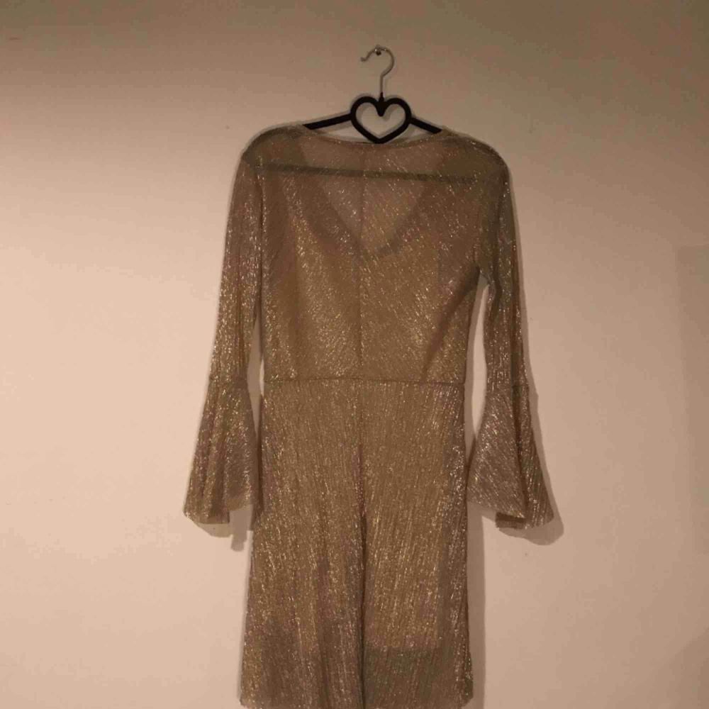Somrig guld-glittrig klänning med underklänning Skick: Oanvänd, köpt second hand. Fraktkostnad tillkommer. Klänningar.