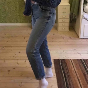  - Mom jeans i snygg denimfärg! Sparsamt använda. Jeansen har knappar istället för dragkedja, det syns lite på bild 3. Kanten på byxbenen längst ned har jag sytt upp lite för hand så vill man ha de typ 2 cm längre så går det lätt att fixa. 