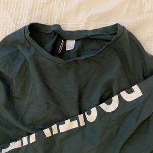 Mörkgrön croppad tröja - Mörkgrön croppad sweatshirt i tunt material. Den har ett tryck på ena armen där det står ”positivity”. Köptes för länge sedan men är inte mycket använd. Säljer den för 100kr men då är också frakten inräknad i priset! Skriv gärna privat vid frågor!:) Strl L men passar också mig med S.