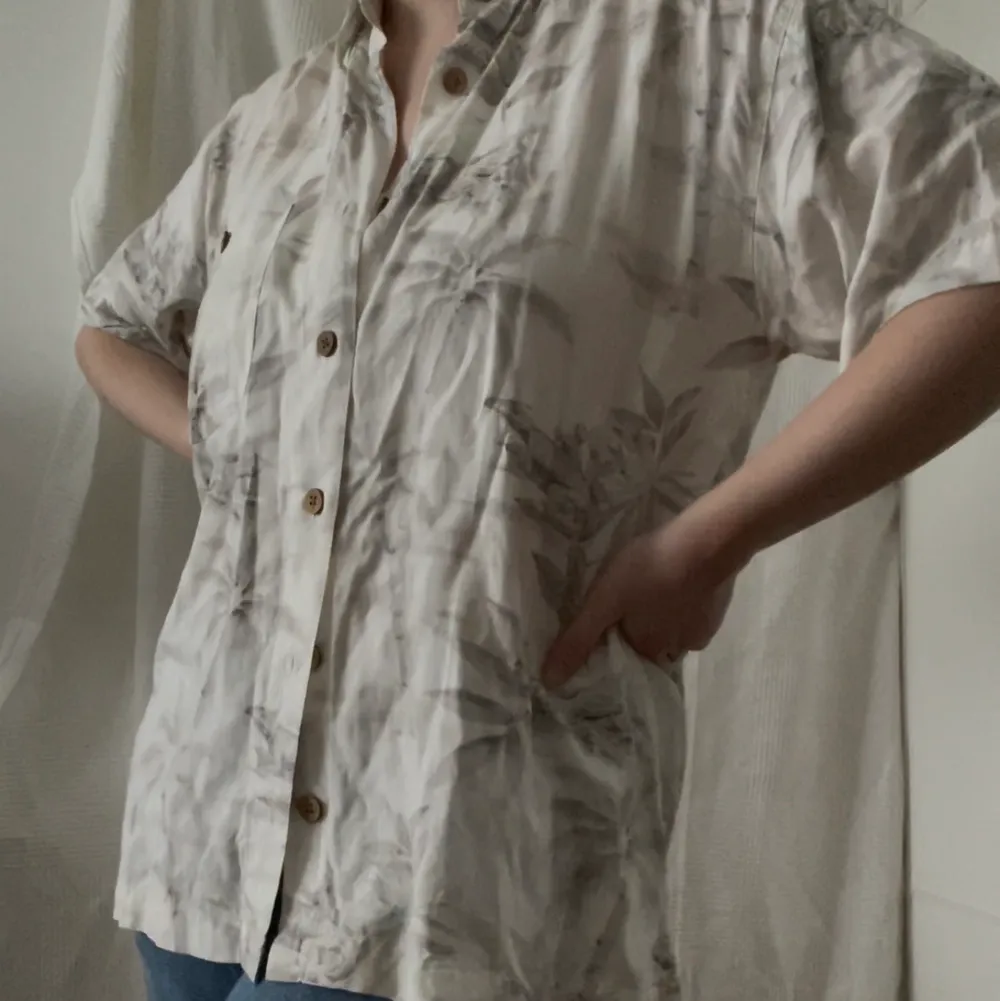 en tunn skjorta med snyggt mönster. träknappar som detalj vid knäppning och på ficka på bröstet. köpt secondhand men i nyskick! . Skjortor.