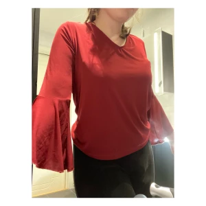 Vinröd tröja - Vinröd tröja med vida armar, lite öppen i ryggen. Storlek M