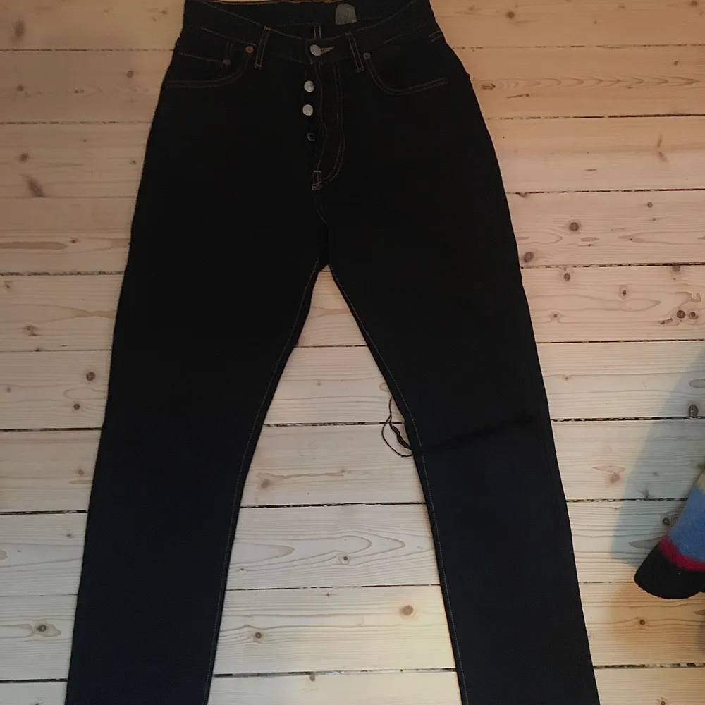 Vintage Levis jeans 501, straight legg. Storlek W34 L30. Färgen är svart med gul/guldiga stygn. Säljes pågrund av för små. Ditsatt hål på vänstra benet (se bild) . Jeans & Byxor.