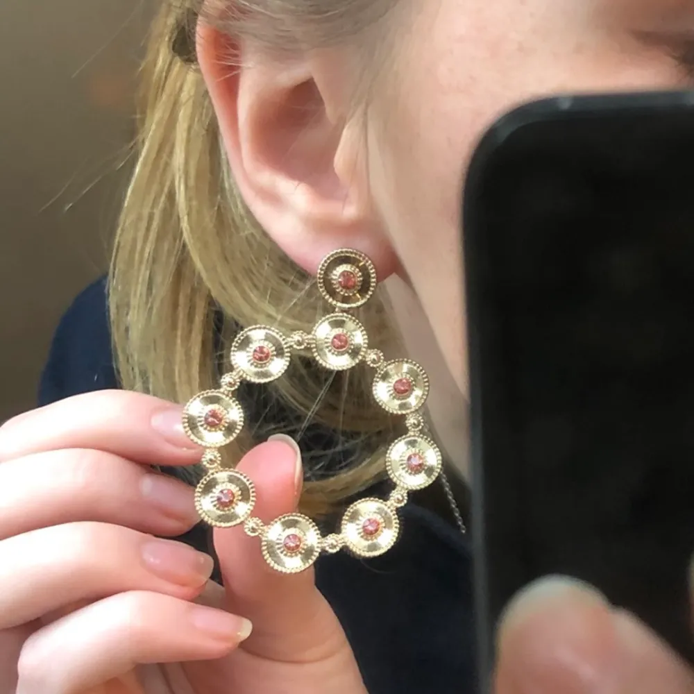 vackra örhängen i guld med små rosa glittrande stenar. unik design, kan bäras till fest eller för att göra en tråkig outfit mer intressant. . Asusteet.