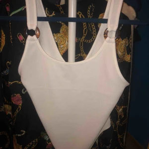  - Body från H&M, strl M. Har en liten fläck smink på ena sidan 