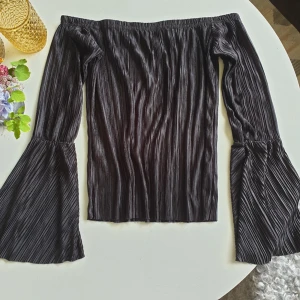  - Så fin offshoulder-tröja med utsvängda ärmar. Lätt glansigt tyg. Resår upptill och i ärmarna innan det utsvängda börjar 