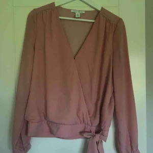  - Rosa blus med knytning i midjan. Passar XS/S. 