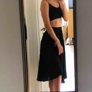  - en plisserad svart kjol 