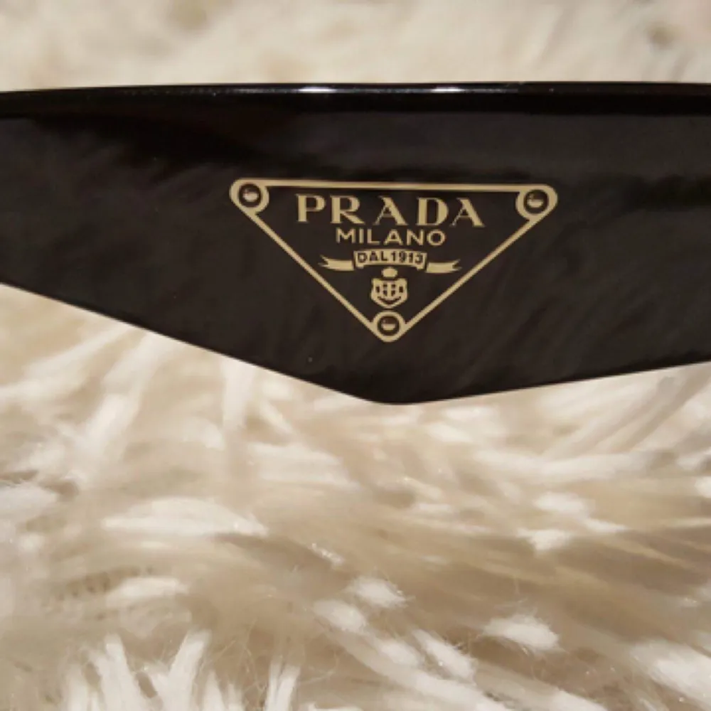 Äkta Prada solglasögon i modellen SPR32PS  Fjärilsram, Heltäckande Båge, Svart Violet Shaded  Inklusive etui Tillverkade i Italien  (Nypris 1900kr) . Accessoarer.
