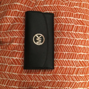  - En stor Michael kors plånbok i bra skick förutom färgen som försvunnit lite på märket som ni ser på bilden annars väldigt bra kvalité. 