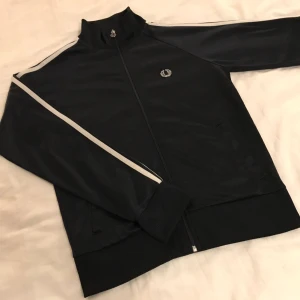  - Fred Perry tröja i mycket bra skick! Inga skador, säljes på grund av att jag tyvärr aldrig använder den. Står att det är storlek 40 men jag har 36-38 och den sitter fint på mig 🙂