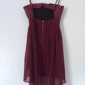 Super snygg vinröd festklänning. Lite längre baktill och med glitter upptill. Från märket Elise Ryan. Aldrig använd.